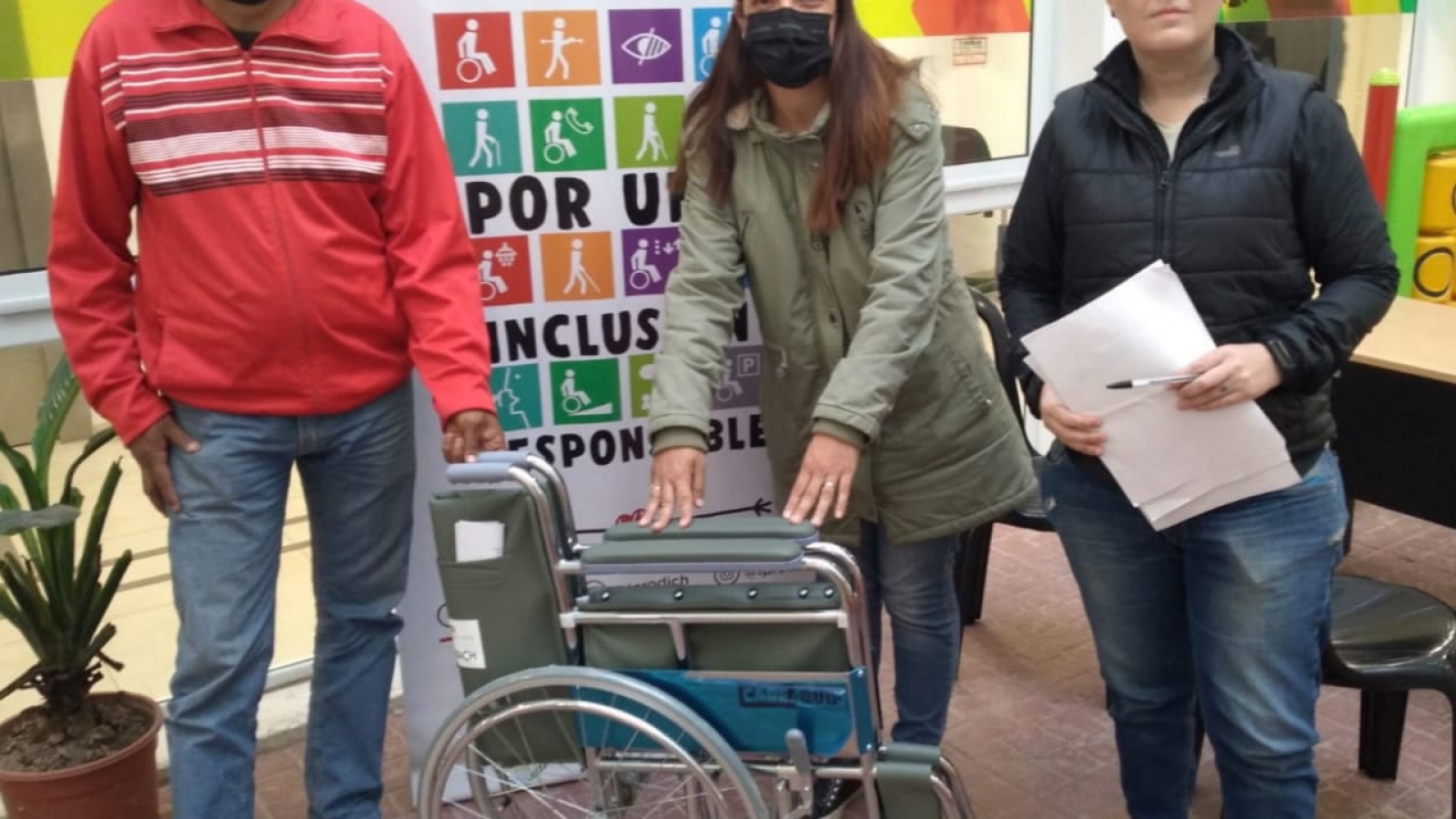 Familiar de beneficiaria mostrando su nueva silla de ruedas