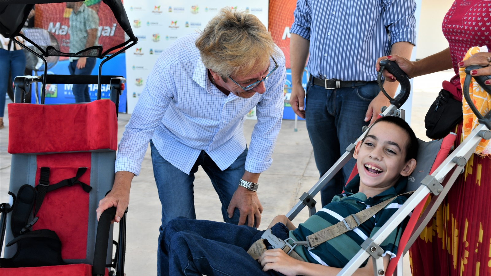 El presidente Lorenzo sonriendo junto a niño con discapacidad que recibió silla de ruedas