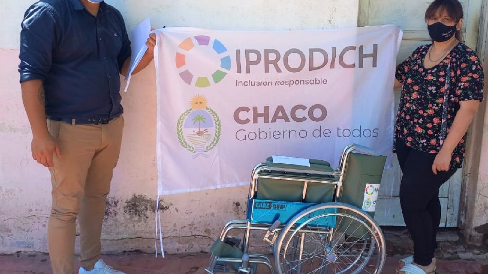 Beneficiaria posando con la bandera del IPRODICH al recibir silla de ruedas